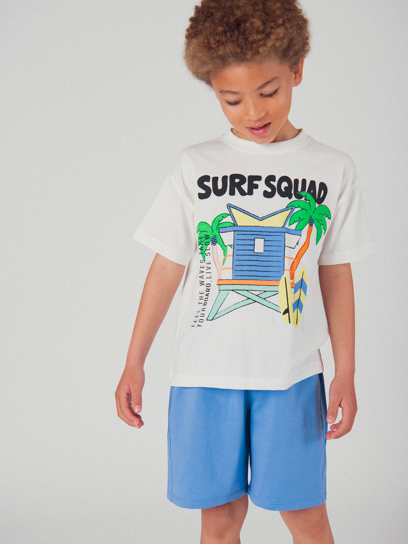 Completo di t-shirt écru e pantaloni corti blu con animazione per bambino
