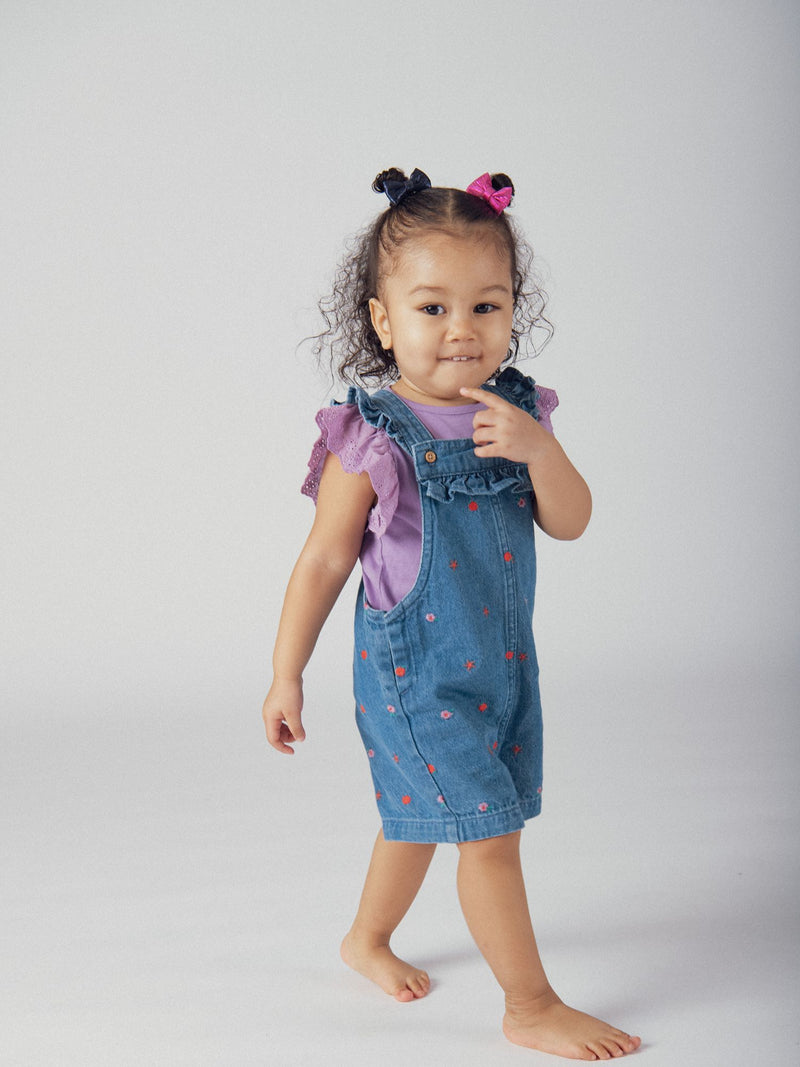 Salopette corta in denim con ricami floreali e fruttati per bambina