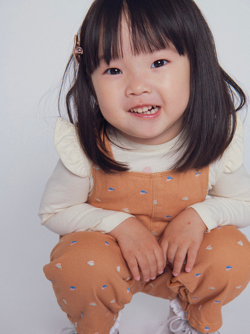 Salopette in twill "caramello" con ricami a forma di cuore per bambine