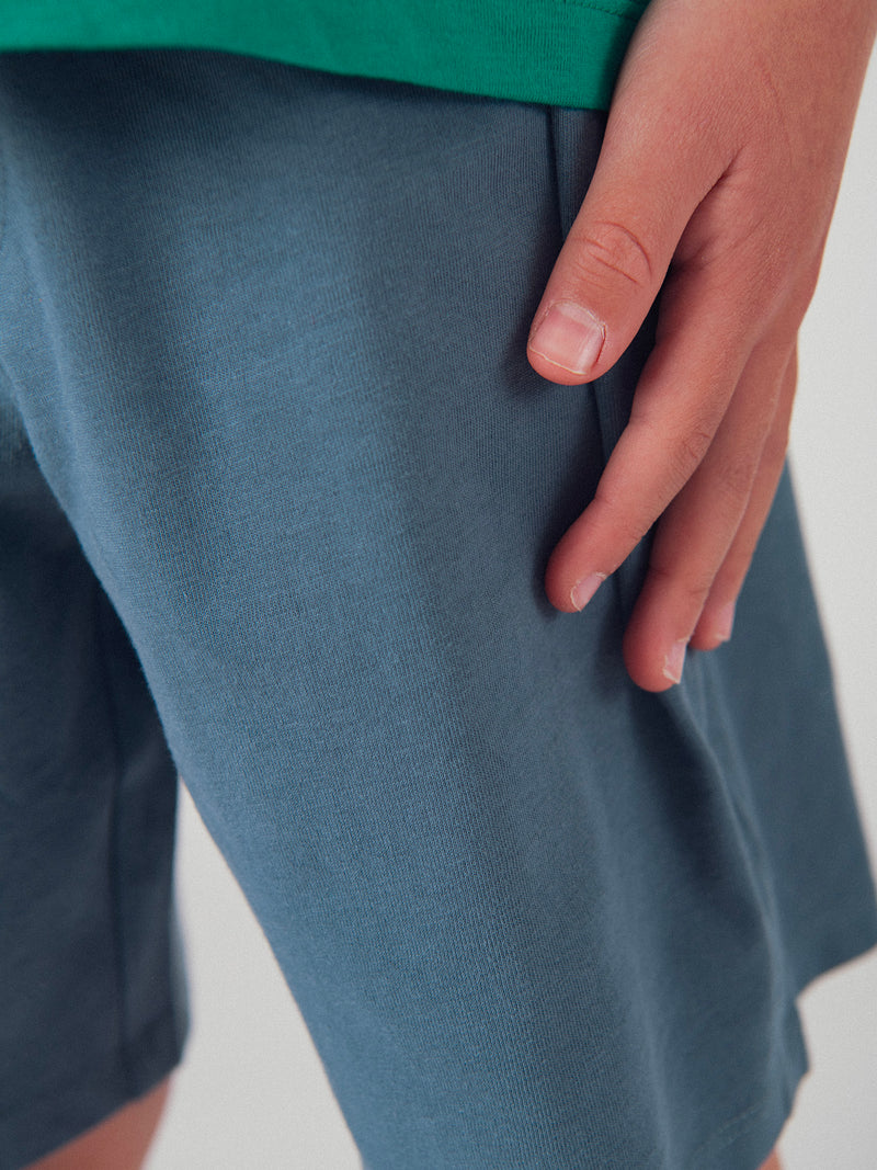 Completo di t-shirt verde e pantaloni corti blu scuro con animazione per ragazzi