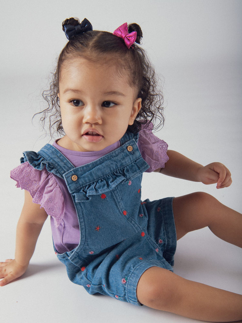 Salopette corta in denim con ricami floreali e fruttati per bambina